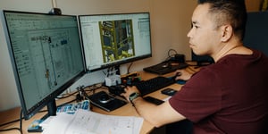 Enhanced Drilling employee looking at technical drawings of EC-Drill Dual MPD on two computer screens