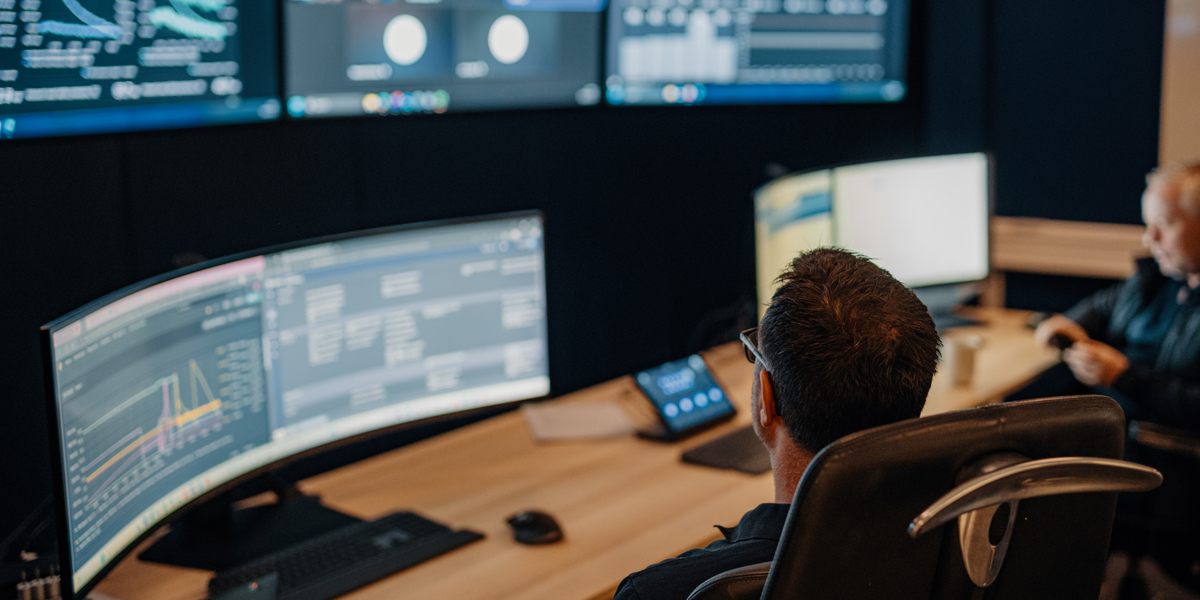 Enhanced Drilling employee in front of computer showing graphs and statistics