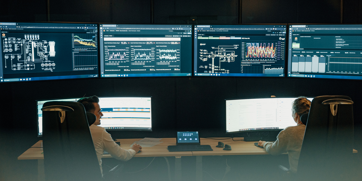 Enhanced Drilling employees sitting in front of computers showing graphs and statistics