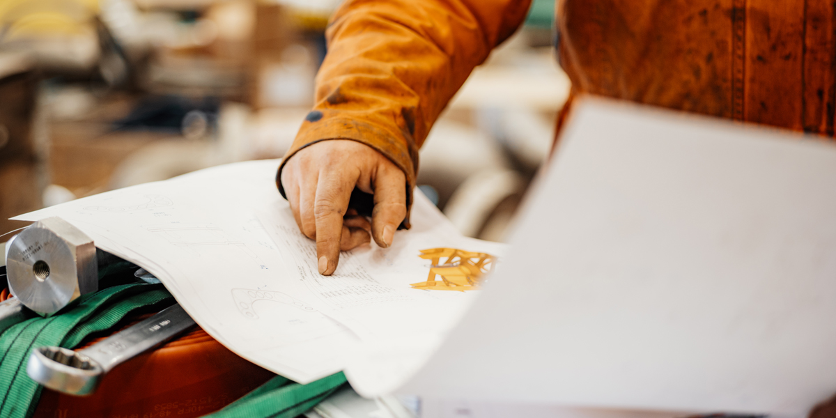 Hand pointing at technical drawing